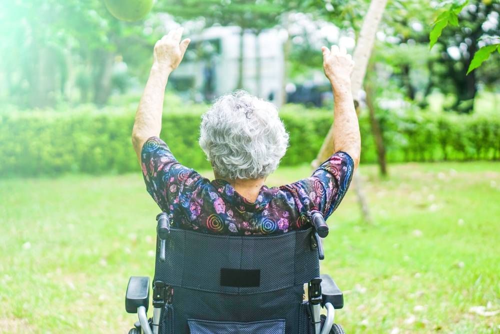 old woman performing wheelchair yoga
